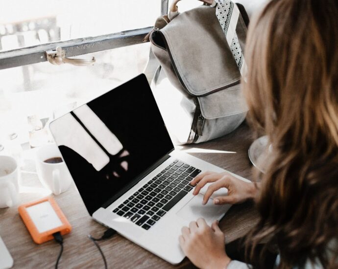 Girl sitting at a laptop and typing text.