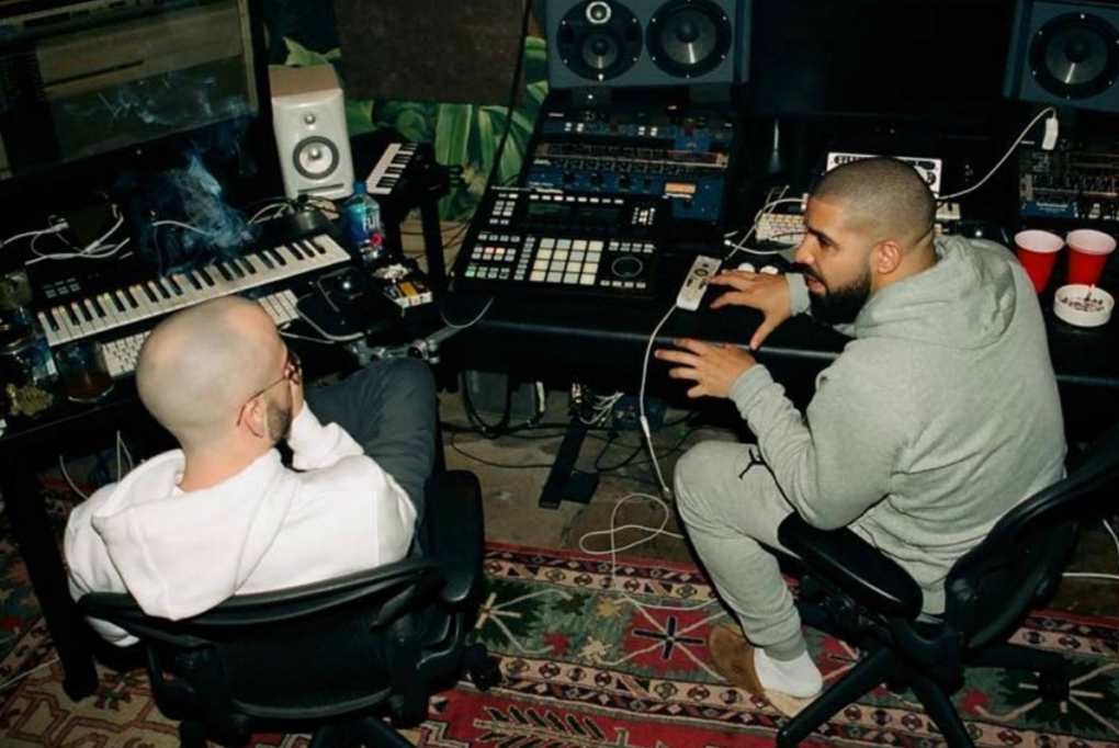 A photo of Drake in the recording studio, surrounded by musical equipment, reflecting his dedication to his craft.