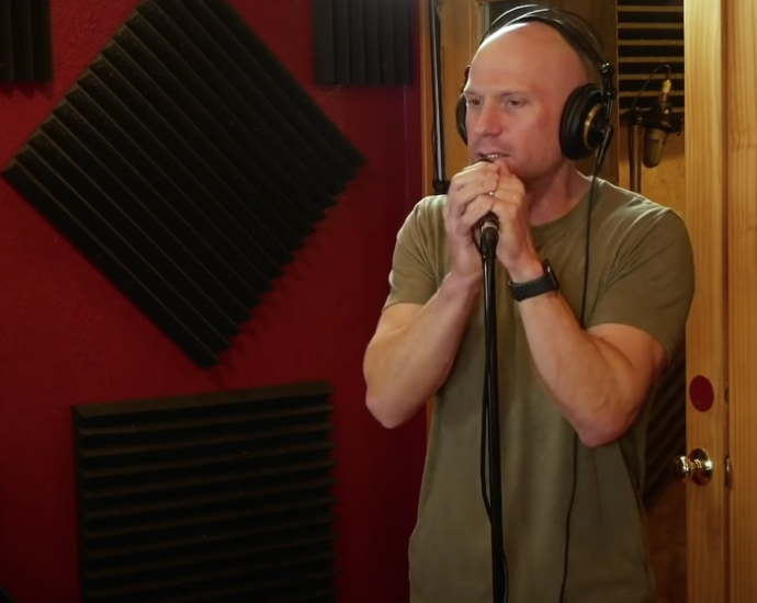 Photo of a guy wearing headphones, holding a microphone with a stand