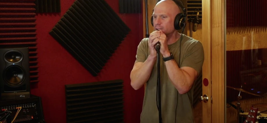 Photo of a guy wearing headphones, holding a microphone with a stand