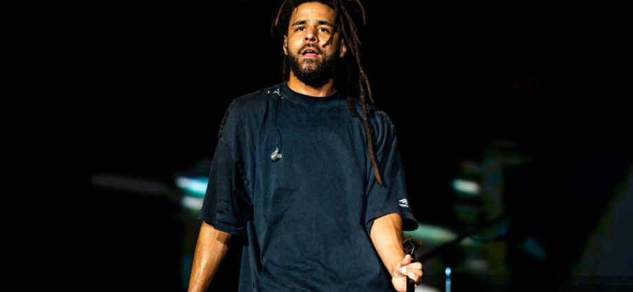 Cole, the renowned rapper, songwriter, and producer, performing on stage with passion and energy.
