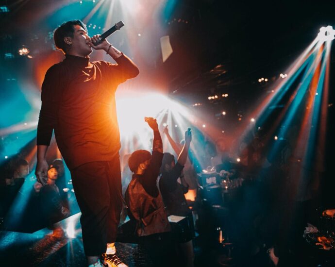 the singer raps on stage, the audience dances.