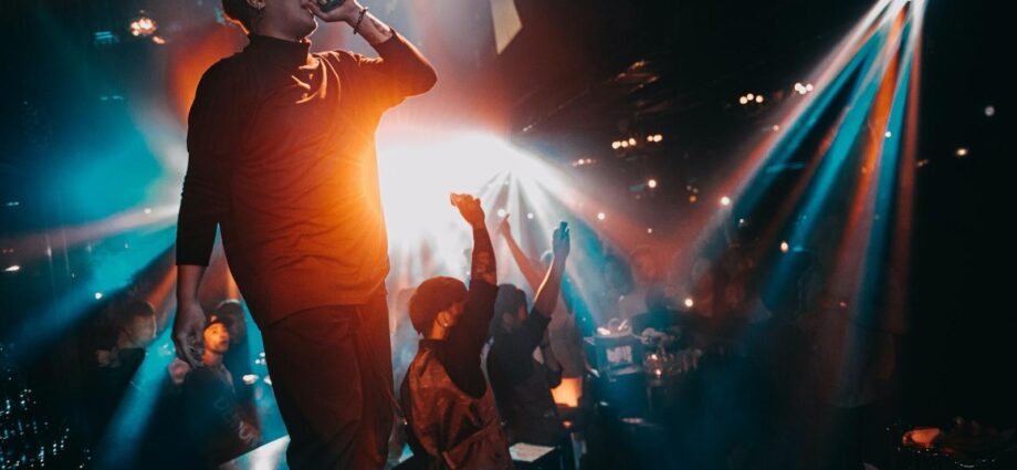 the singer raps on stage, the audience dances.