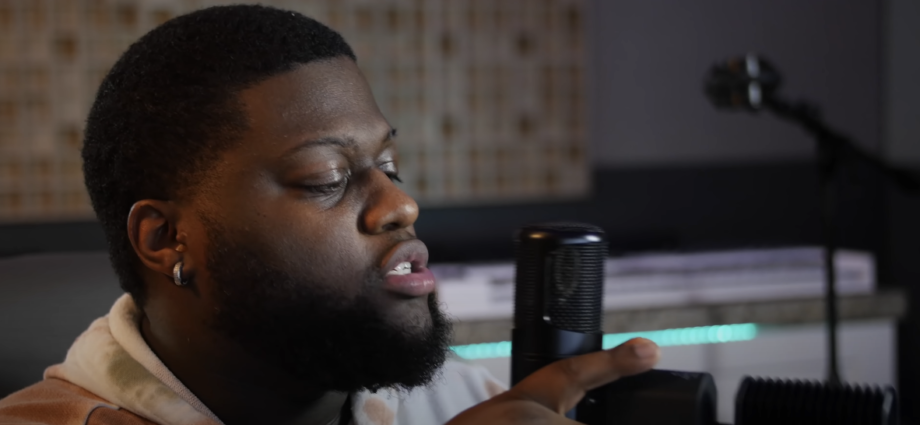 Photo of a guy singing into a microphone with a filter attached